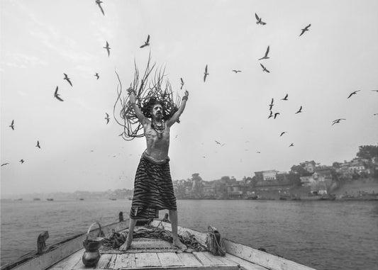 Naga Sadhu poseert op een boot in Varanasi | Achtergrond